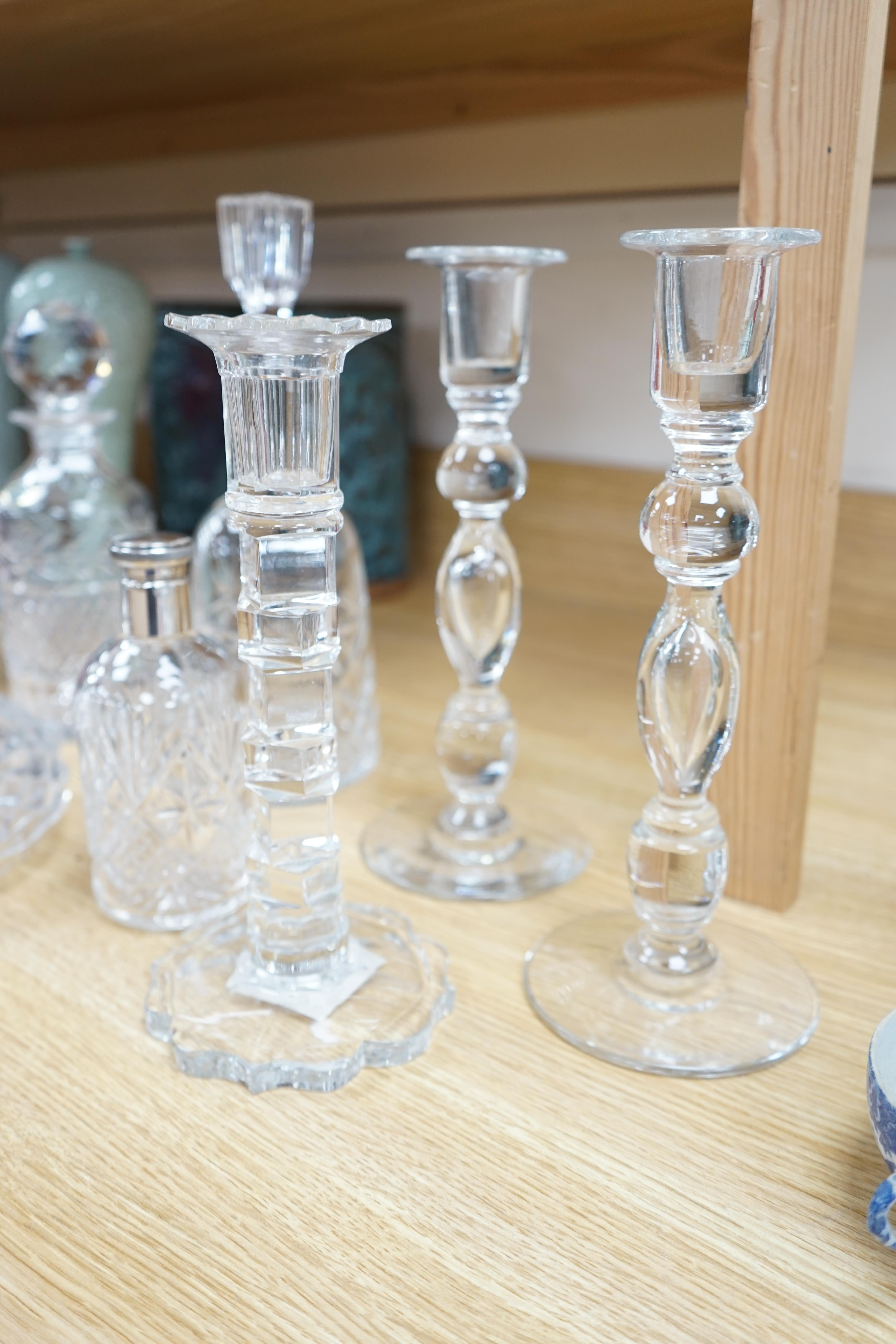 A cut glass ship’s decanter, two others and three various cut glass candle sticks, tallest decanter 30cm high. Condition - good